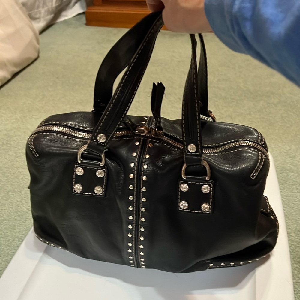 Black studded bag with some stains on the inside of bag